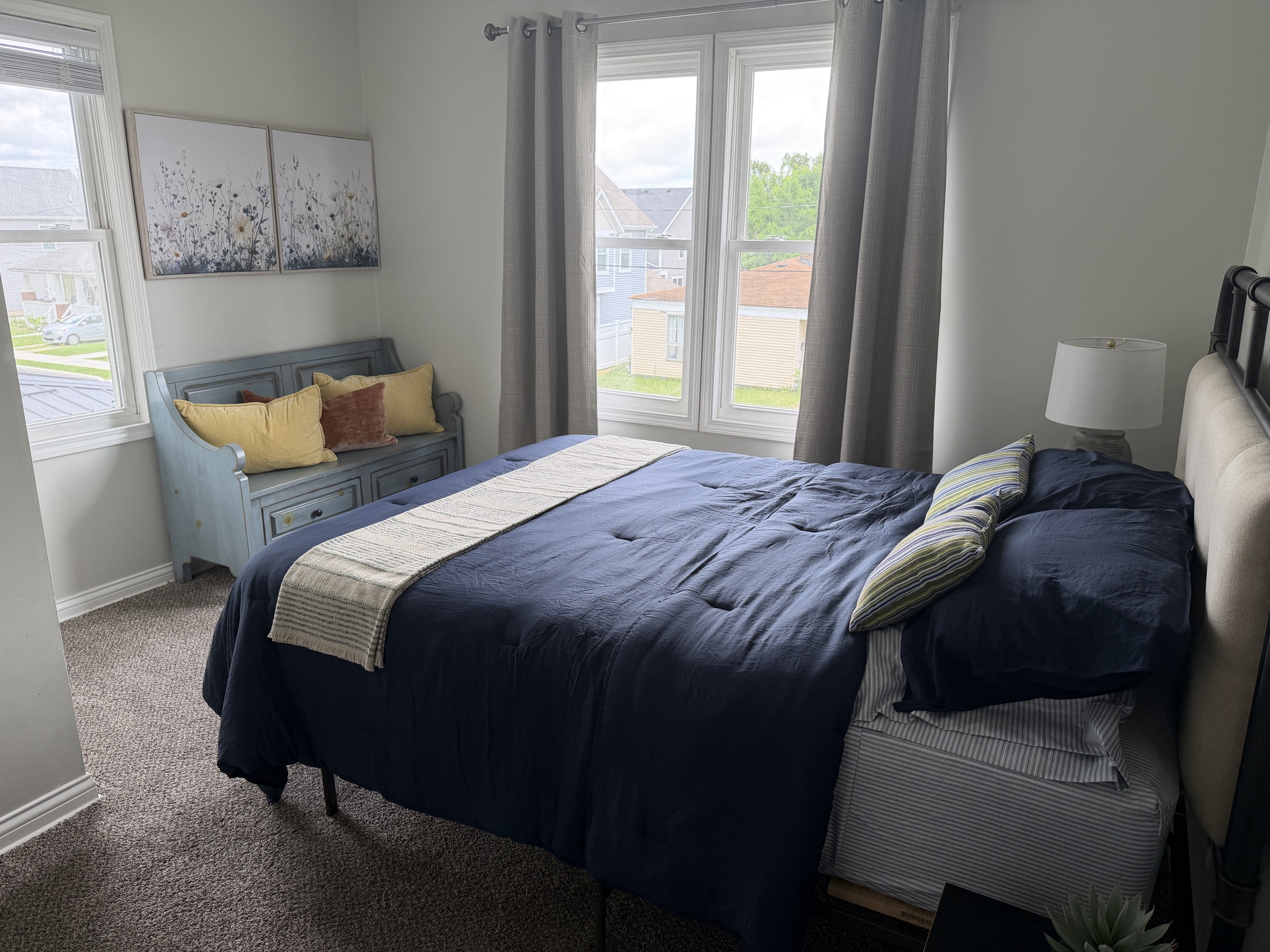 Bedroom with blue bedding and large windows