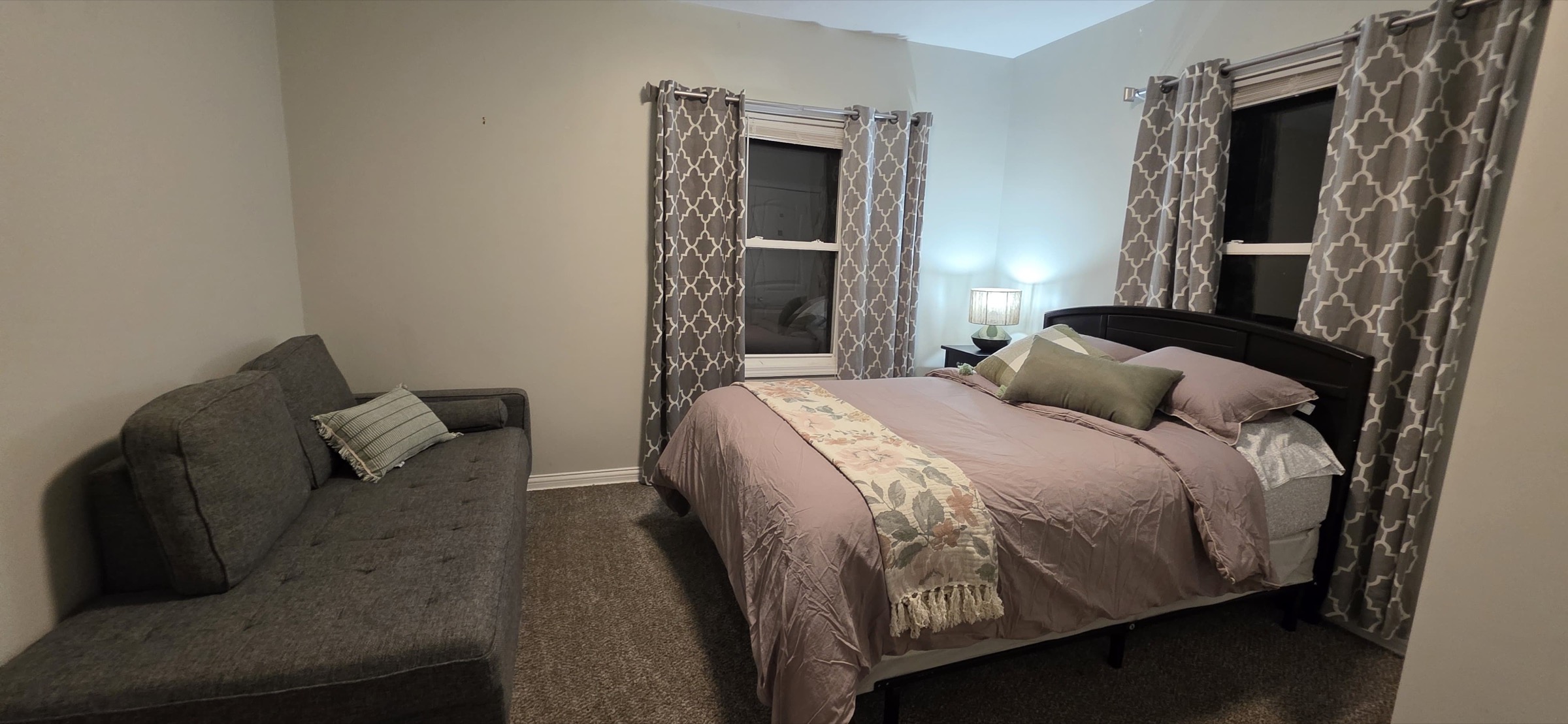 Bedroom with rose bedding and sofa
